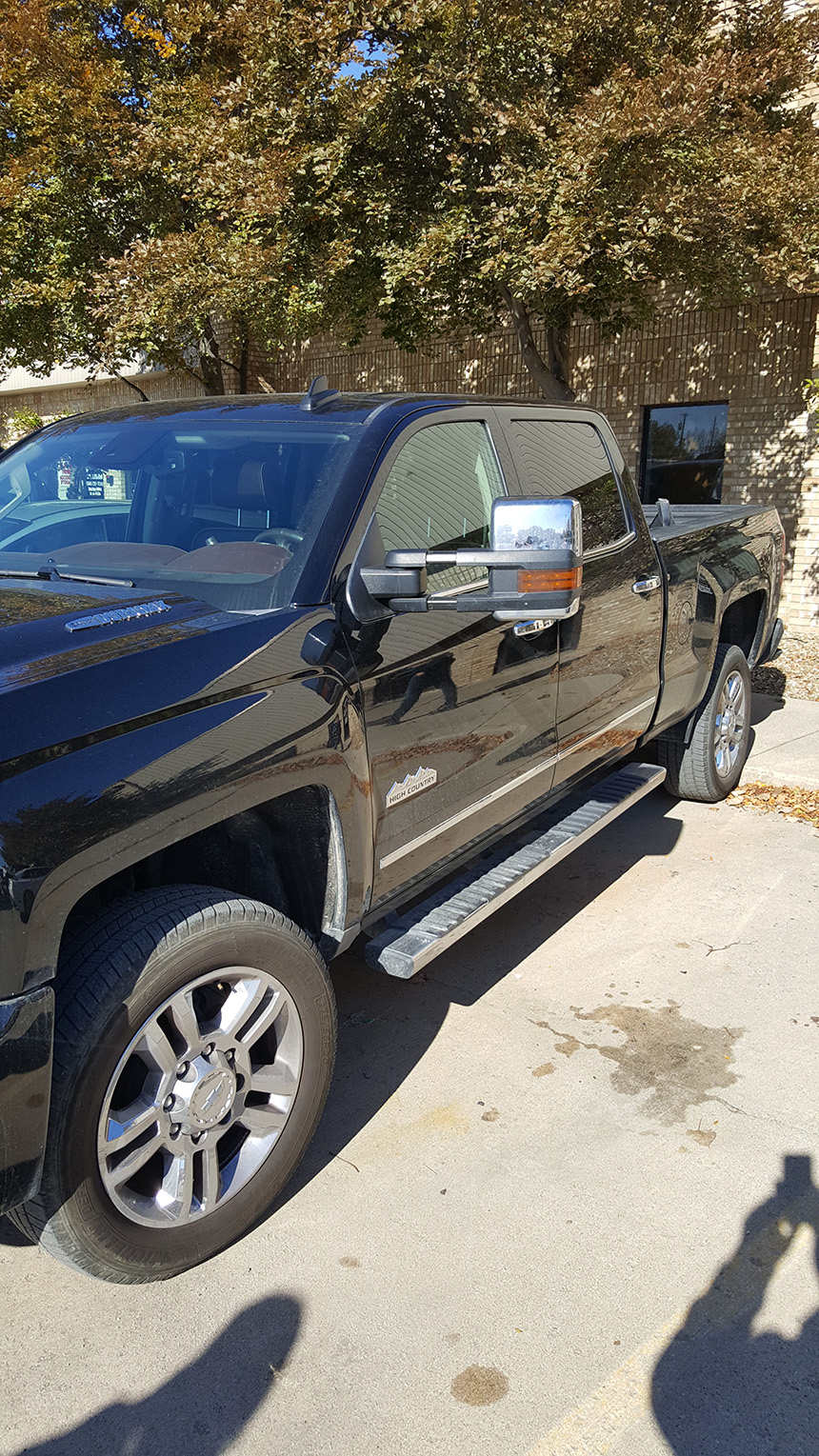 The image shows a black pickup truck parked outdoors during daylight, with no visible text or people.